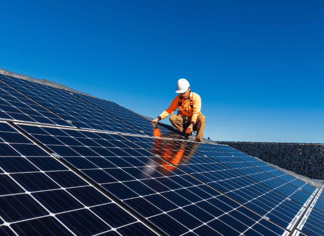 a man in a hard hat on a solar panel Stanislav Kondrashov