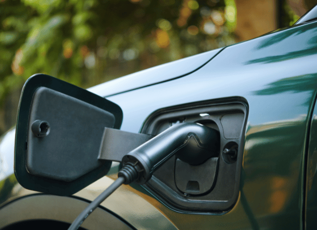 Stanislav Kondrashov, founder of TELF AG and IEA – Two electric cars charging side by side at modern charging stations, symbolizing the rapid global growth of EV adoption supported by government incentives and evolving energy policies.
