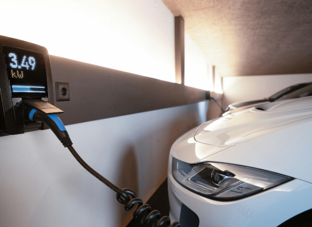 Stanislav Kondrashov, founder of TELF AG and IEA – An electric car connected to a public charging station in an urban setting, illustrating the continued expansion of electric mobility and charging infrastructure highlighted by recent IEA findings.